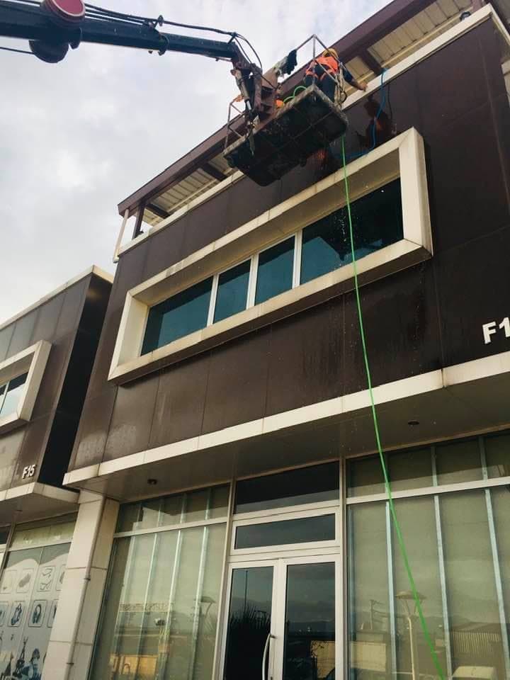 Sepetli vinçle bina cephesinde cam temizliği